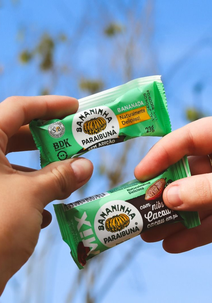 Mãos segurando duas barrinhas de cereal 