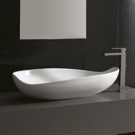Lavabo da bagno ovale di colore bianco con bordo curvo a forma di foglia e rubinetto moderno color argento su un piano di lavoro scuro.