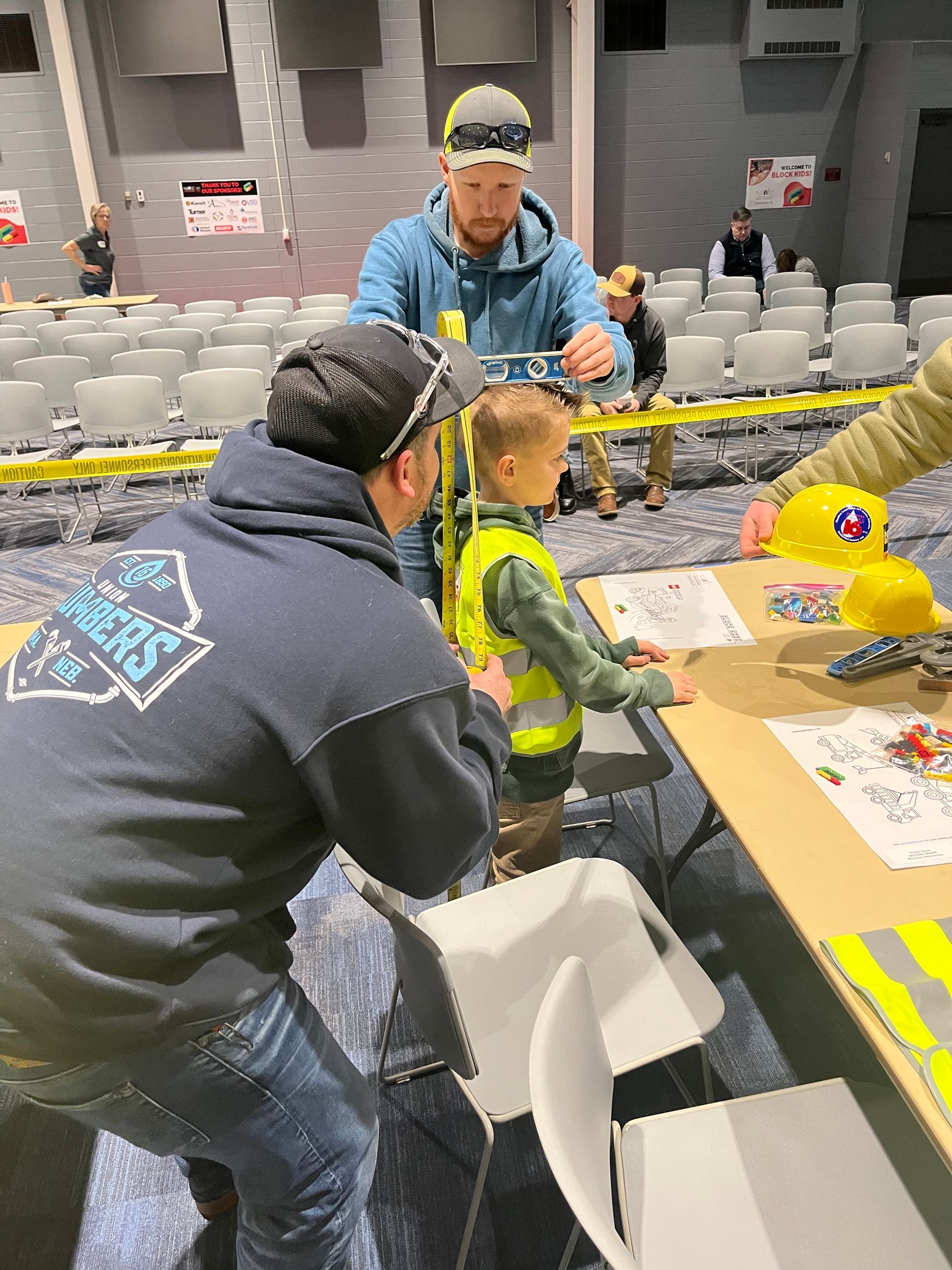 A group of people are sitting around a table playing with toys.