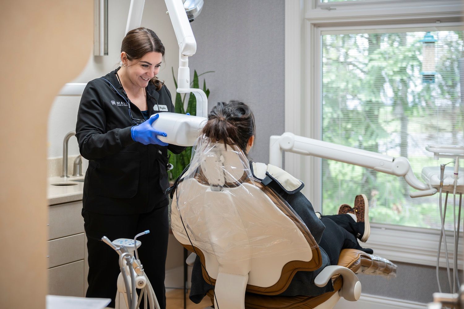 A dental hygienist is taking x-rays of a patient's teeth at Maley Family Dental