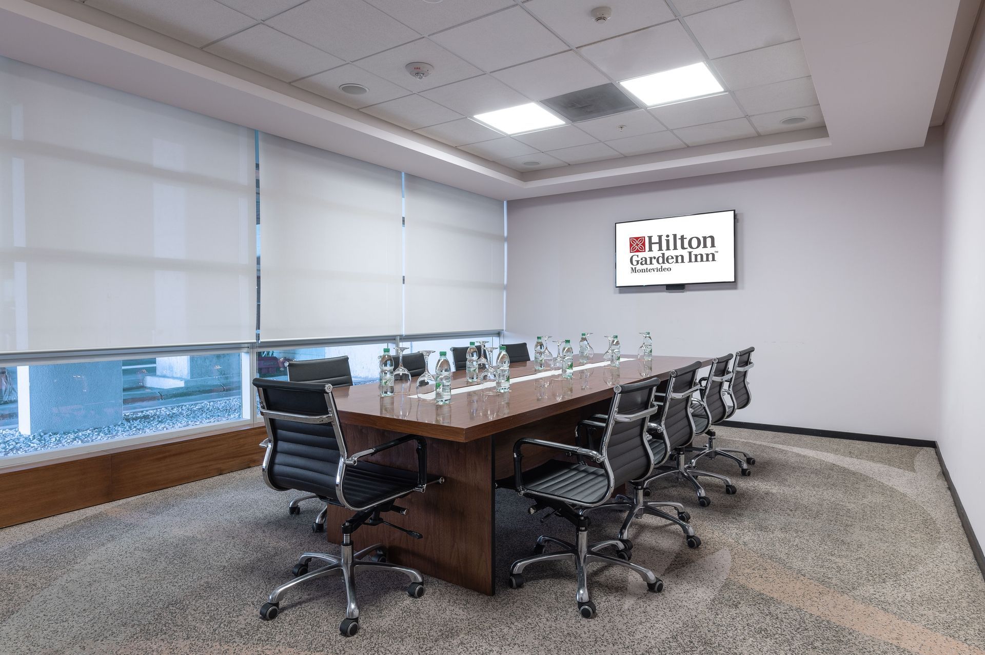 Una sala de conferencias con una mesa larga y sillas.