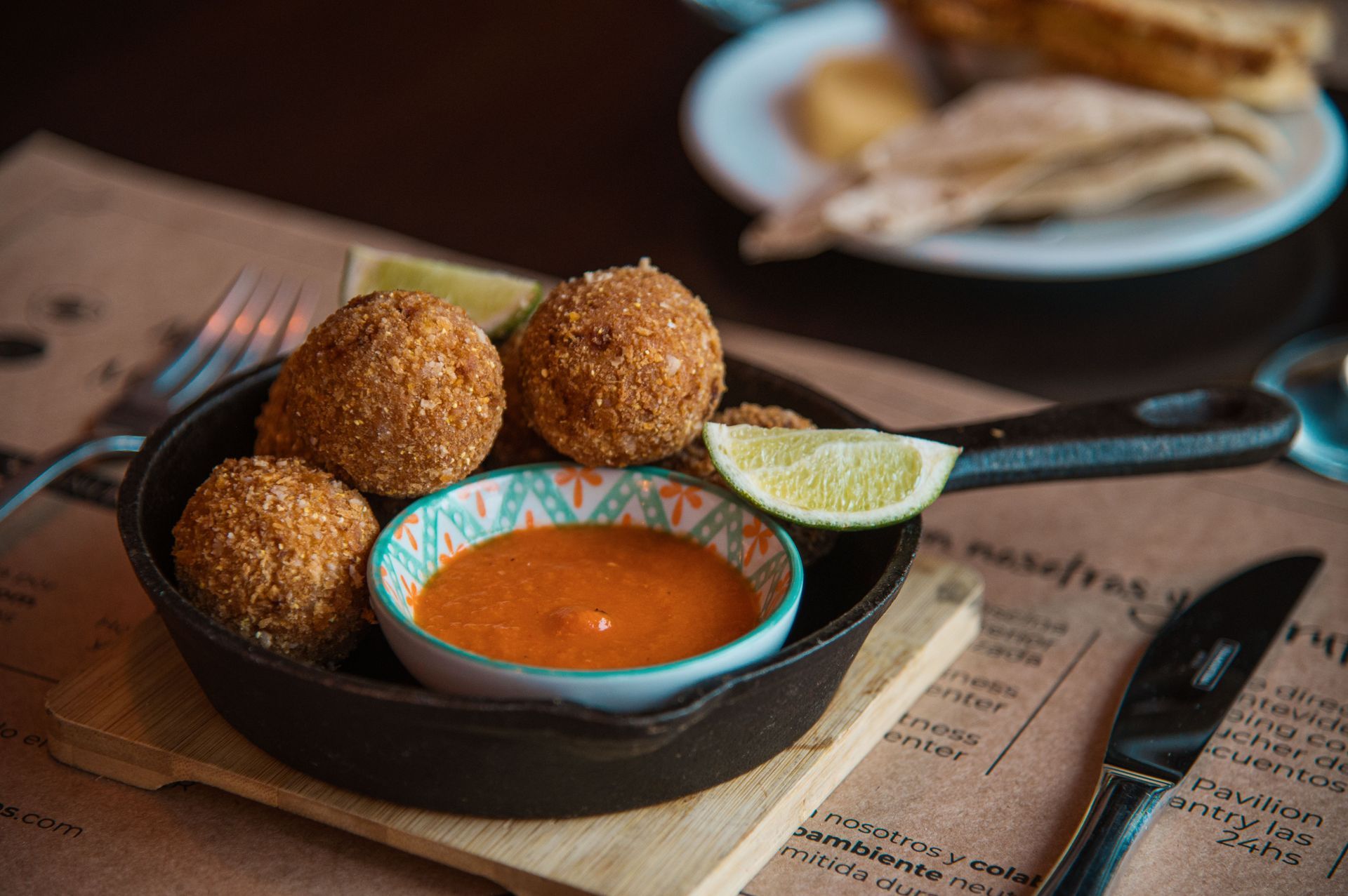 Un plato de comida con salsa y una rodaja de limón sobre una mesa.