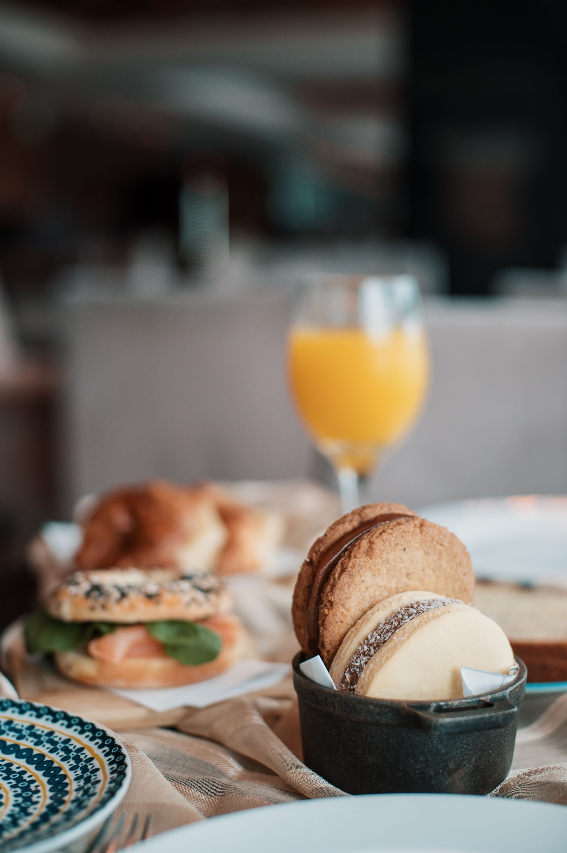 Una mesa cubierta con platos de comida y un vaso de zumo de naranja.