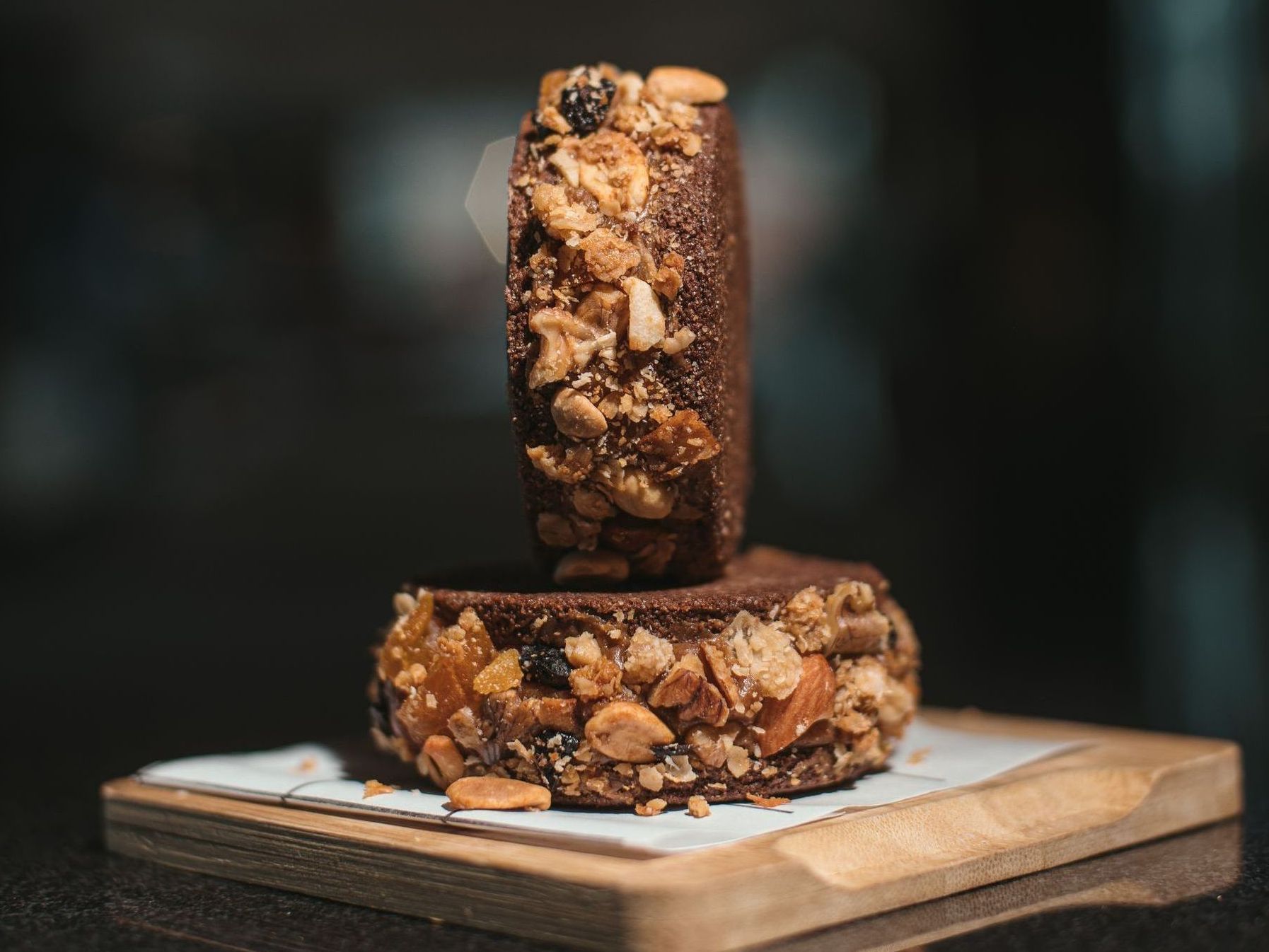 Dos brownies están apilados uno encima del otro sobre una tabla de cortar de madera.