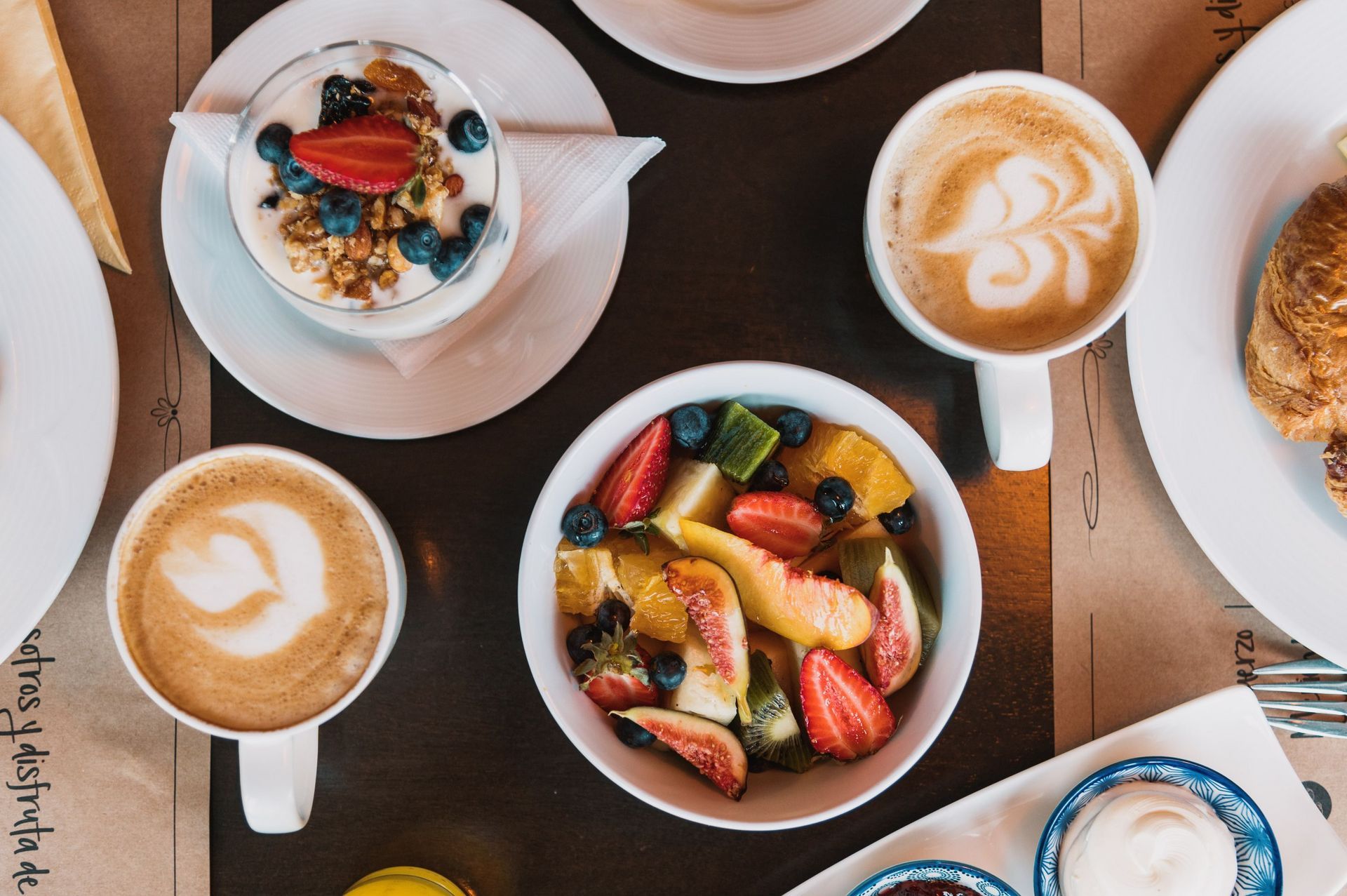 Una mesa cubierta con platos de comida y tazas de café.