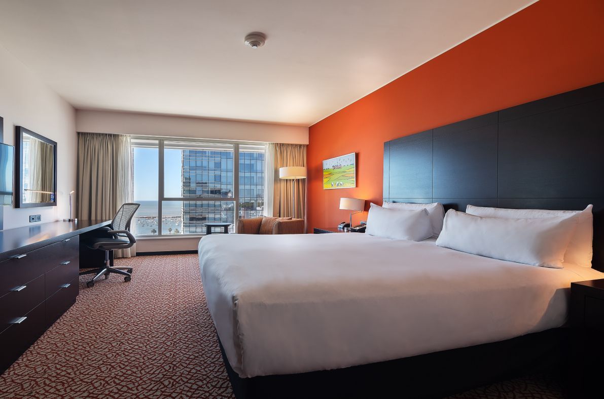 Una habitación de hotel con una cama king size y un gran ventanal.