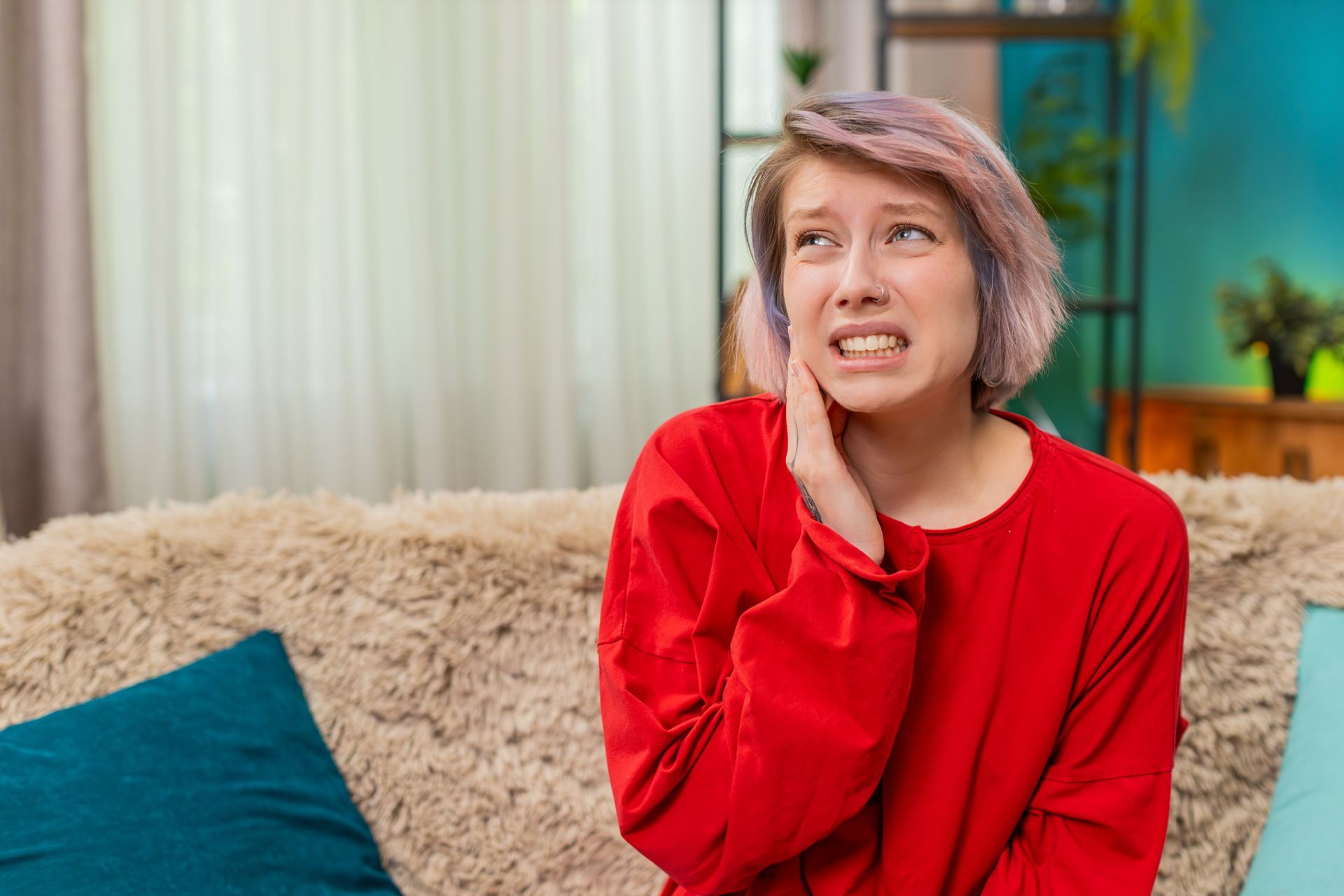 Woman holding her cheek in pain from a severe toothache.