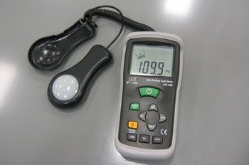 A light meter is sitting on a table next to a light meter. A light meter is sitting on a table next to a light meter.
