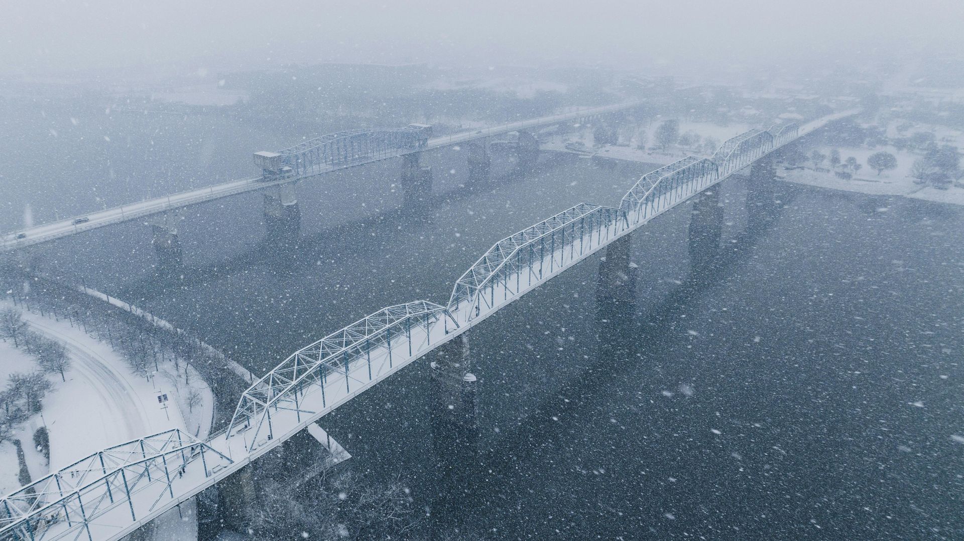 An aerial view of a bridge covered in snow.