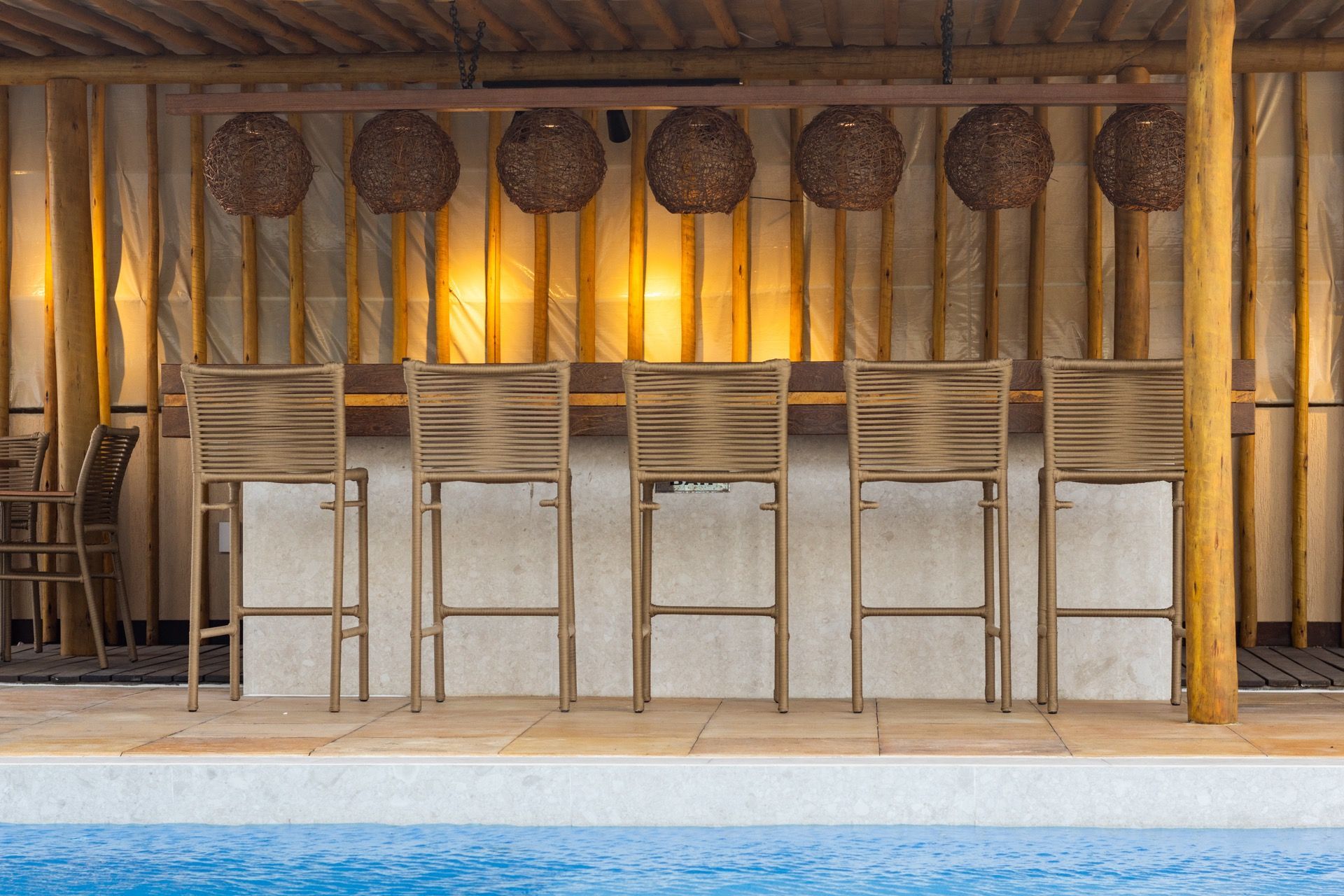 Uma fileira de cadeiras ao lado de uma piscina.