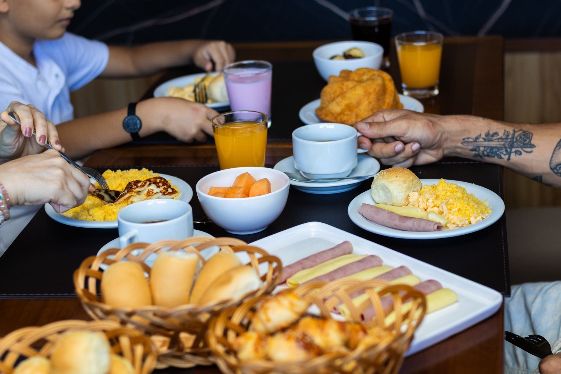 Um grupo de pessoas está sentado à mesa tomando café da manhã.