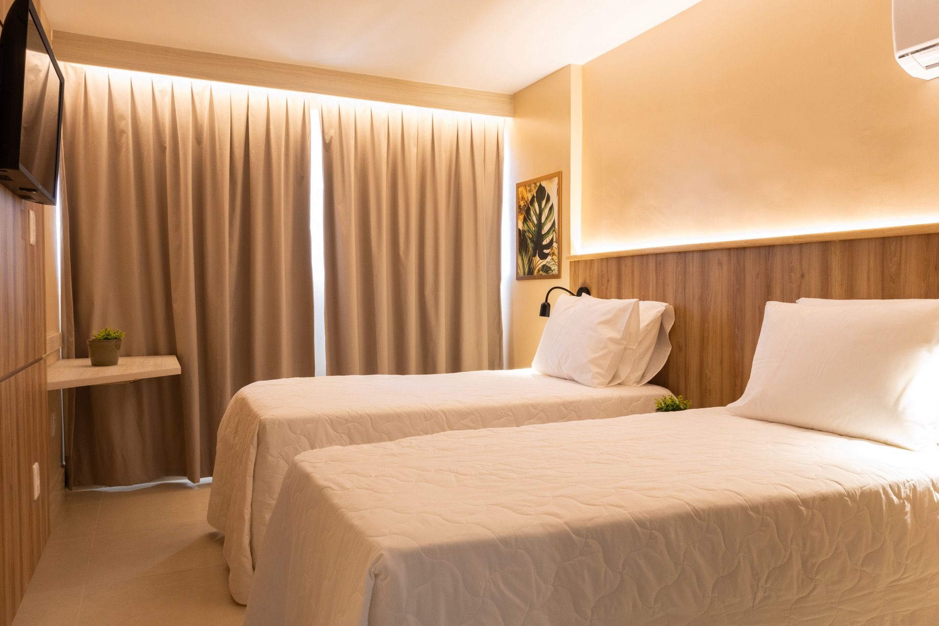 Um quarto de hotel com duas camas e uma TV de tela plana.