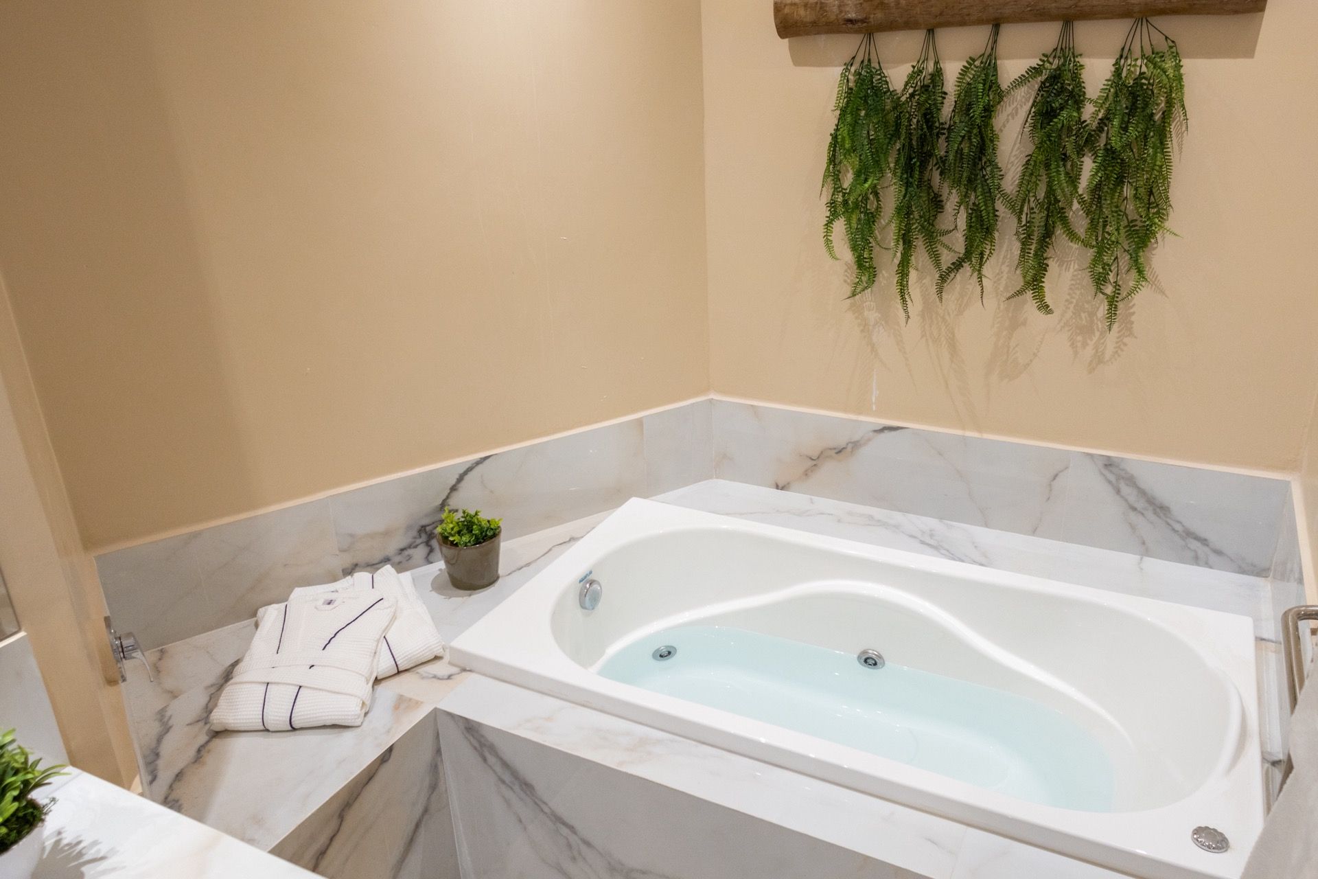 Um banheiro com banheira de hidromassagem cheia de água.