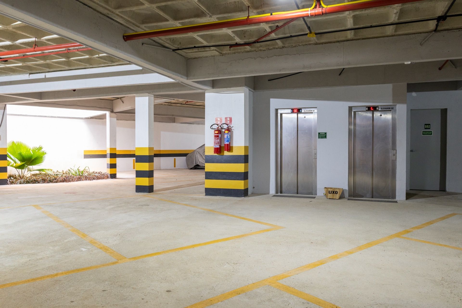 Uma garagem com dois elevadores e um extintor de incêndio