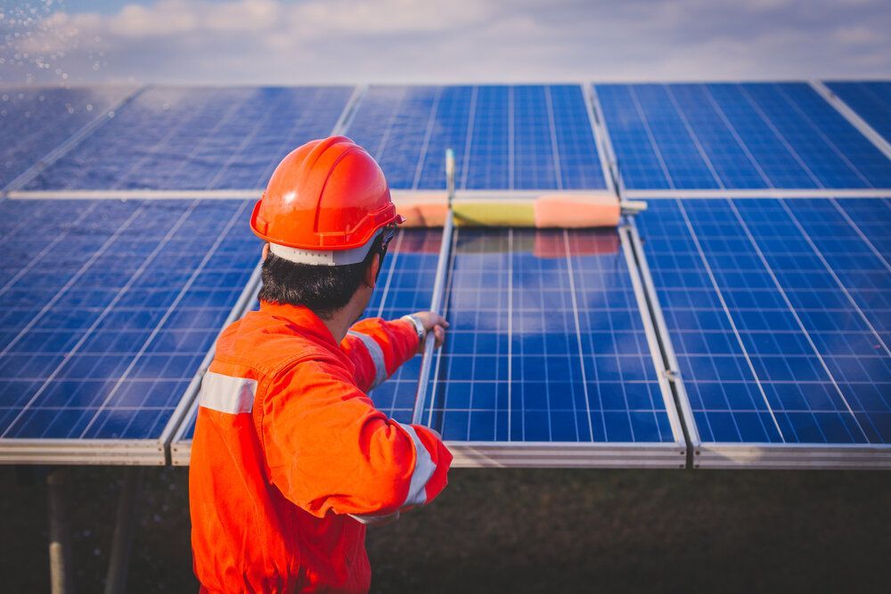 Man is Cleaning Solar Panels With a Brush — Abstract Window Cleaning in Kingscliff, NSW