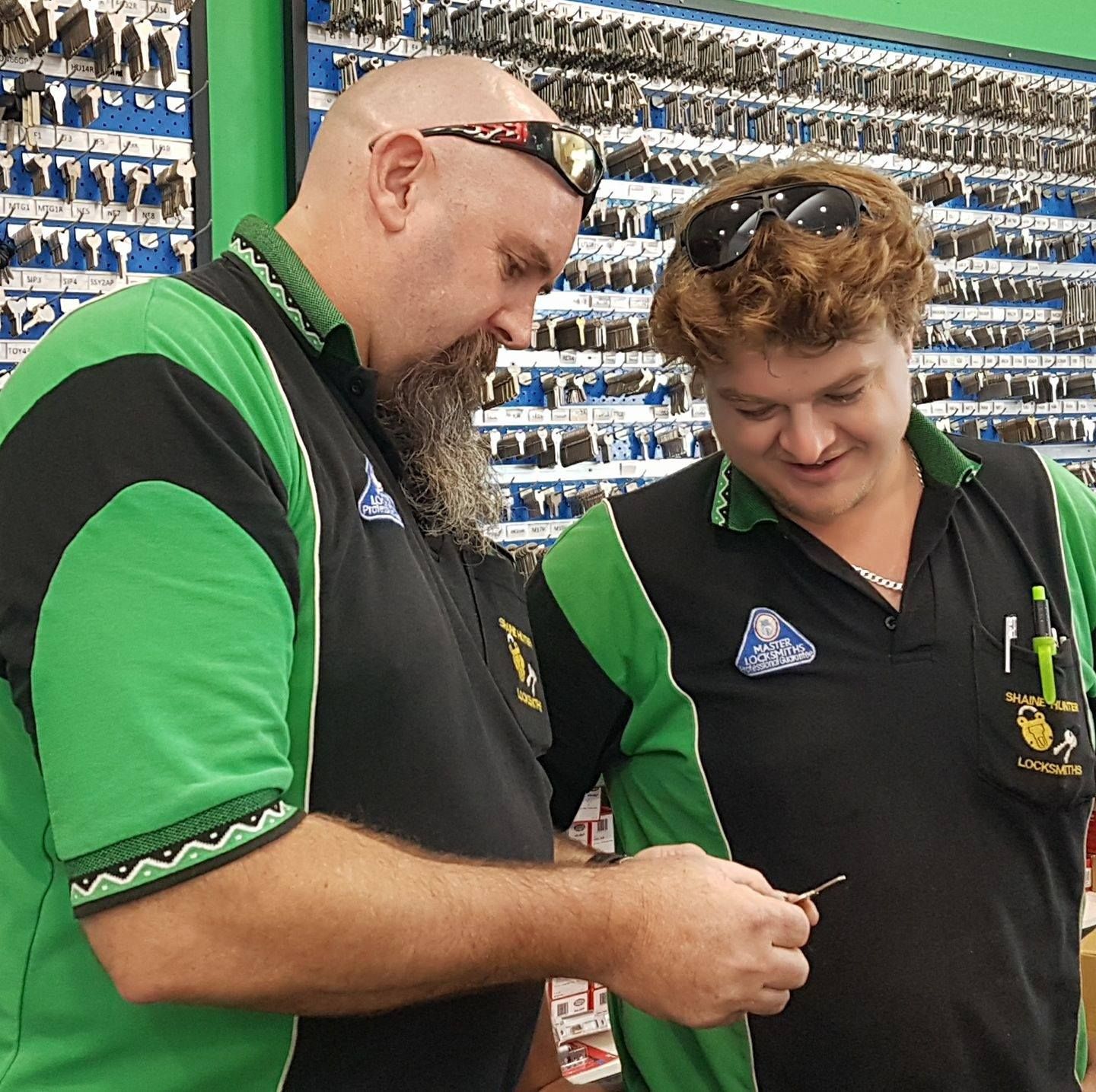 Two Locksmiths Examining a Key at a Key-cutting Shop — Shaine Hunter Locksmiths in Richmond, QLD
