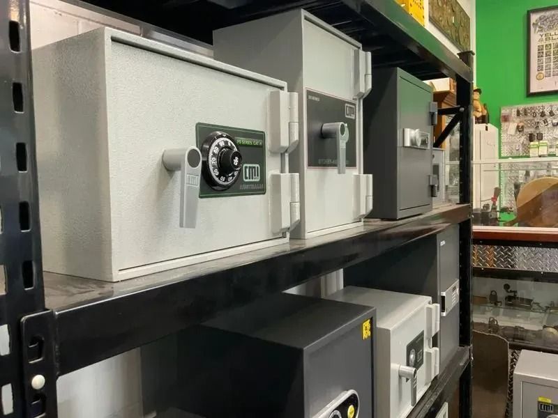 Metal Safes of Various Sizes on a Black Shelf, Displayed in a Store — Shaine Hunter Locksmiths in Mount Isa City, QLD