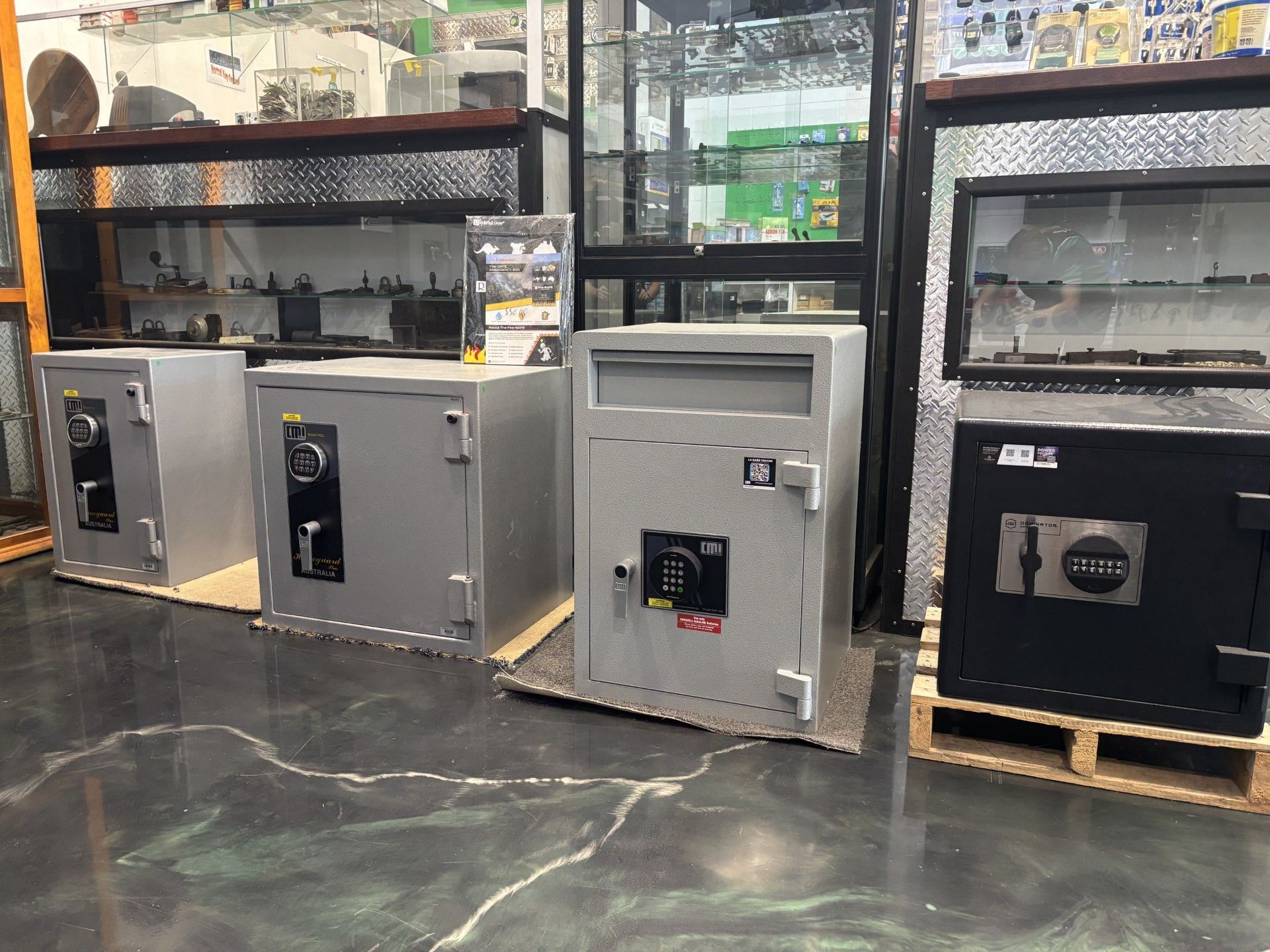 Safes Displayed in a Store, Varying Sizes and Colors — Shaine Hunter Locksmiths in Richmond, QLDre in the Background.