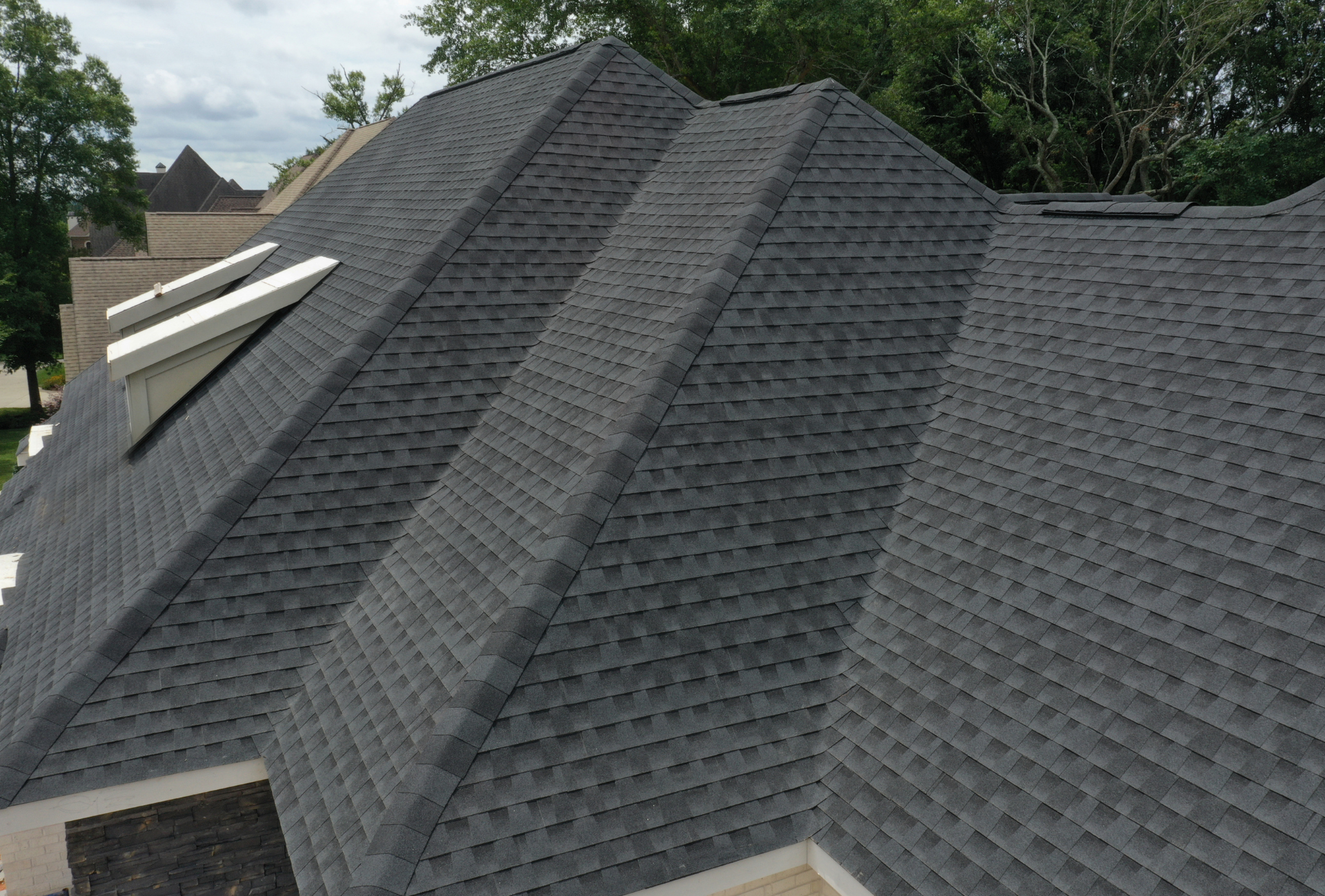 An aerial view of a large house with a gray roof.