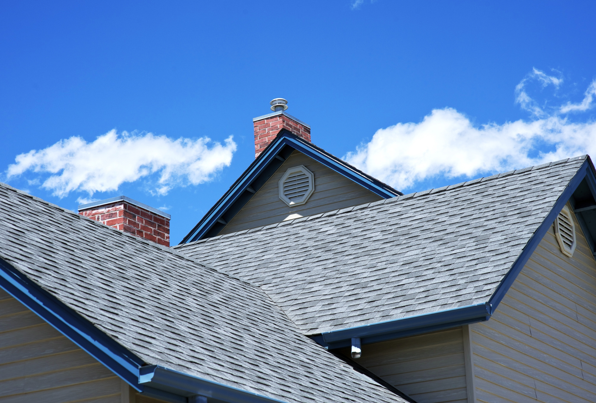A house with a gray roof and a chimney on top of it.