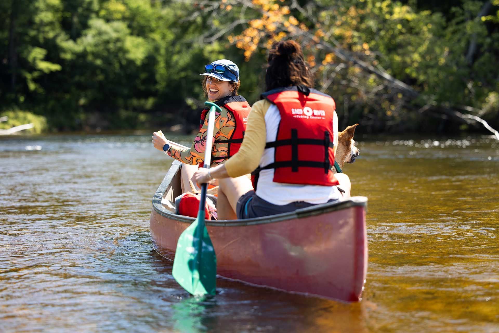 A mother and a child are in a canoe on a river