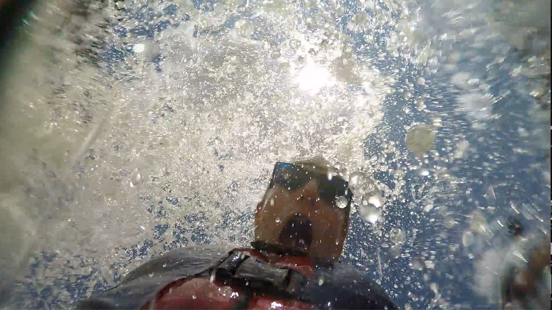 A person wearing goggles is swimming in a pool.