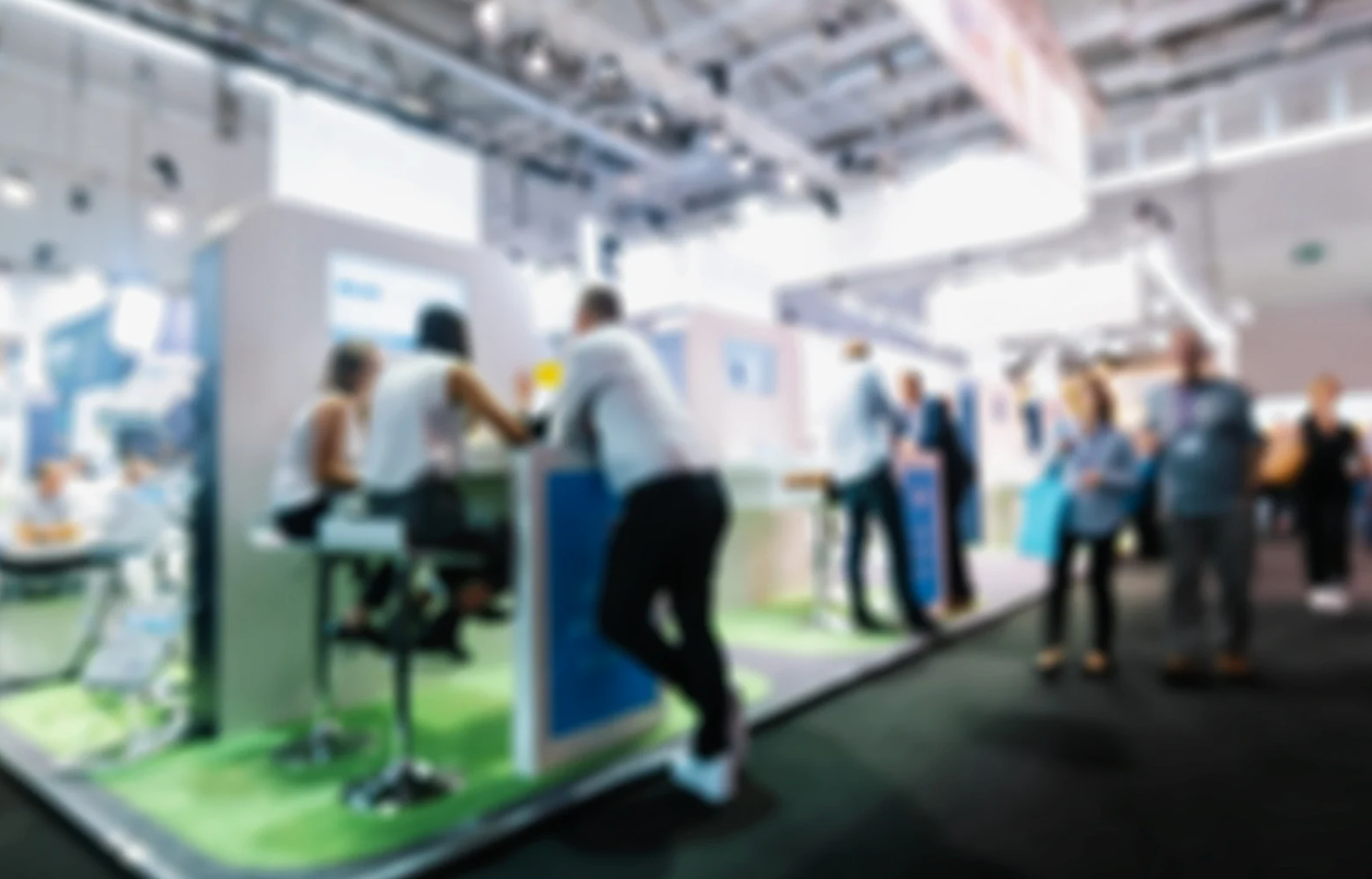 people standing and talking at a tradeshow booth 