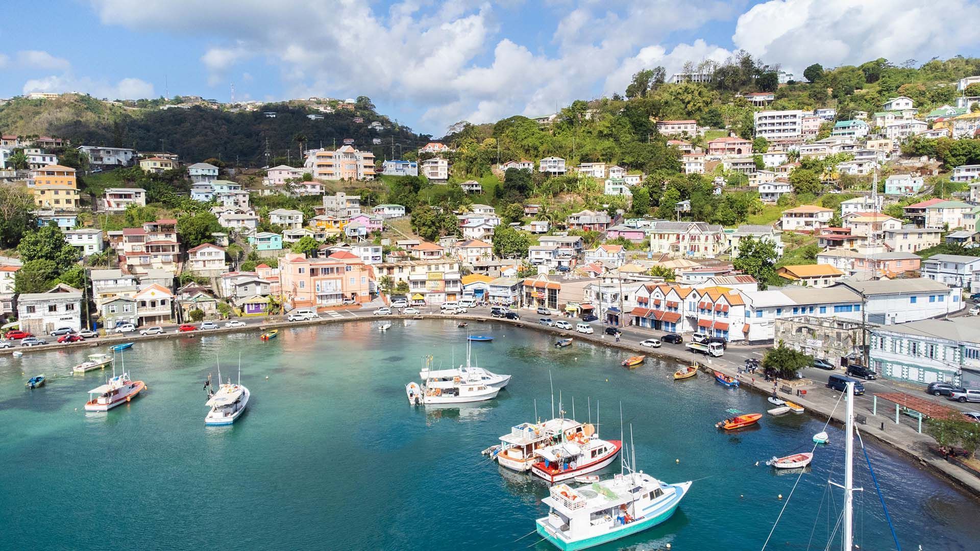 An aerial view of a harbor with boats and a city in the background.