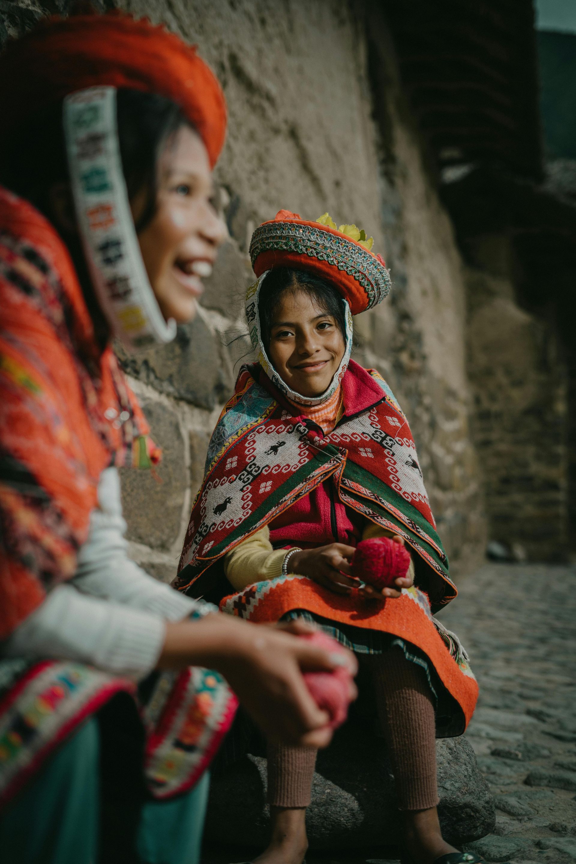 two girls in local culture attire smiling and laughing