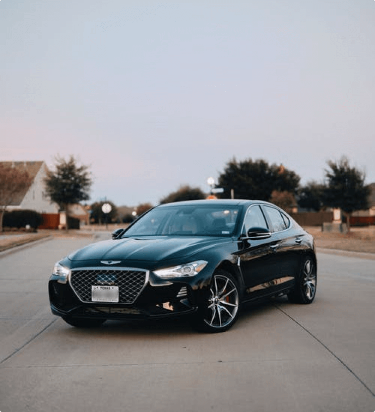 Black Luxury Sedan on suburban street at dusk