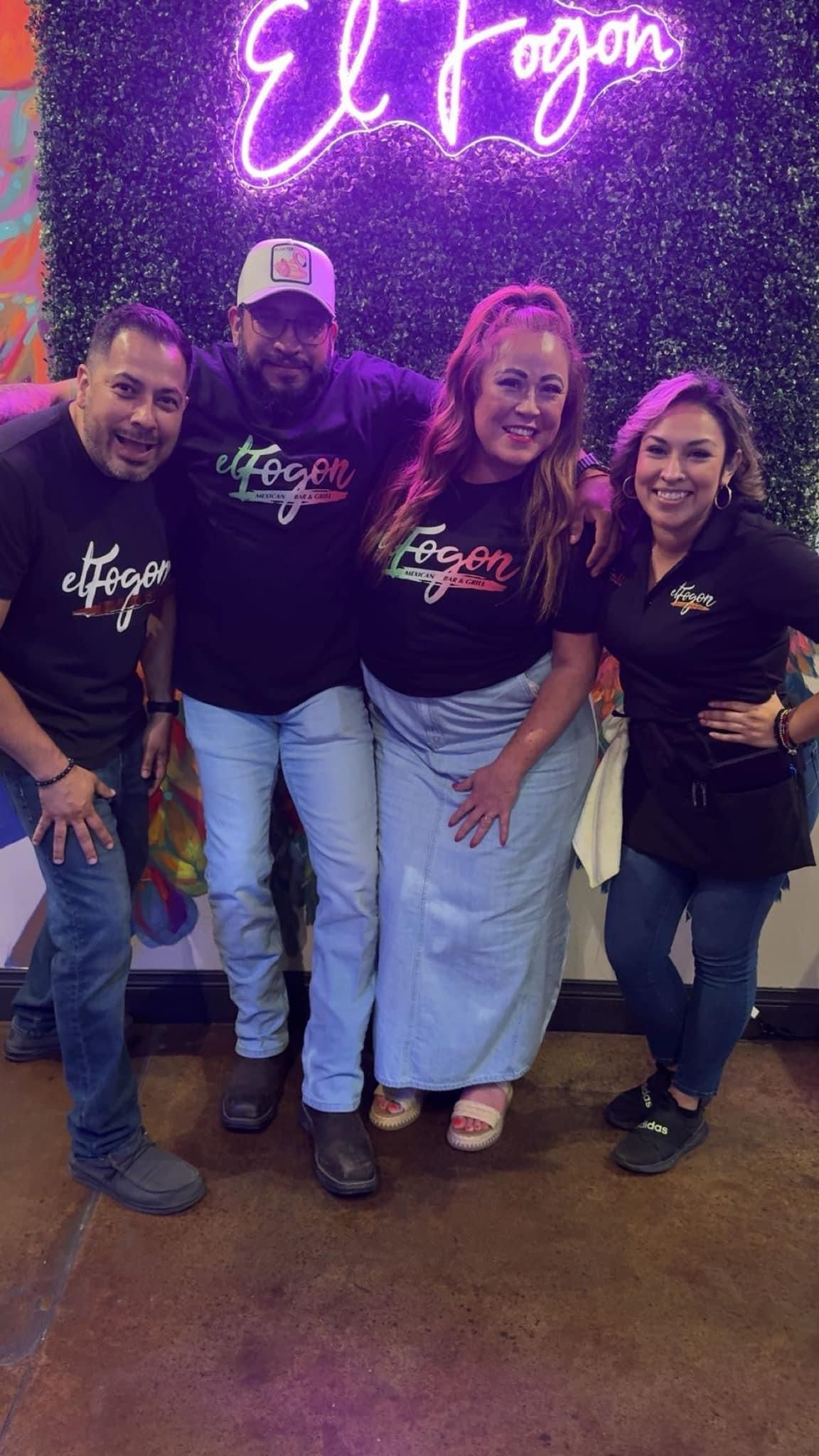 Four people smiling, wearing black 