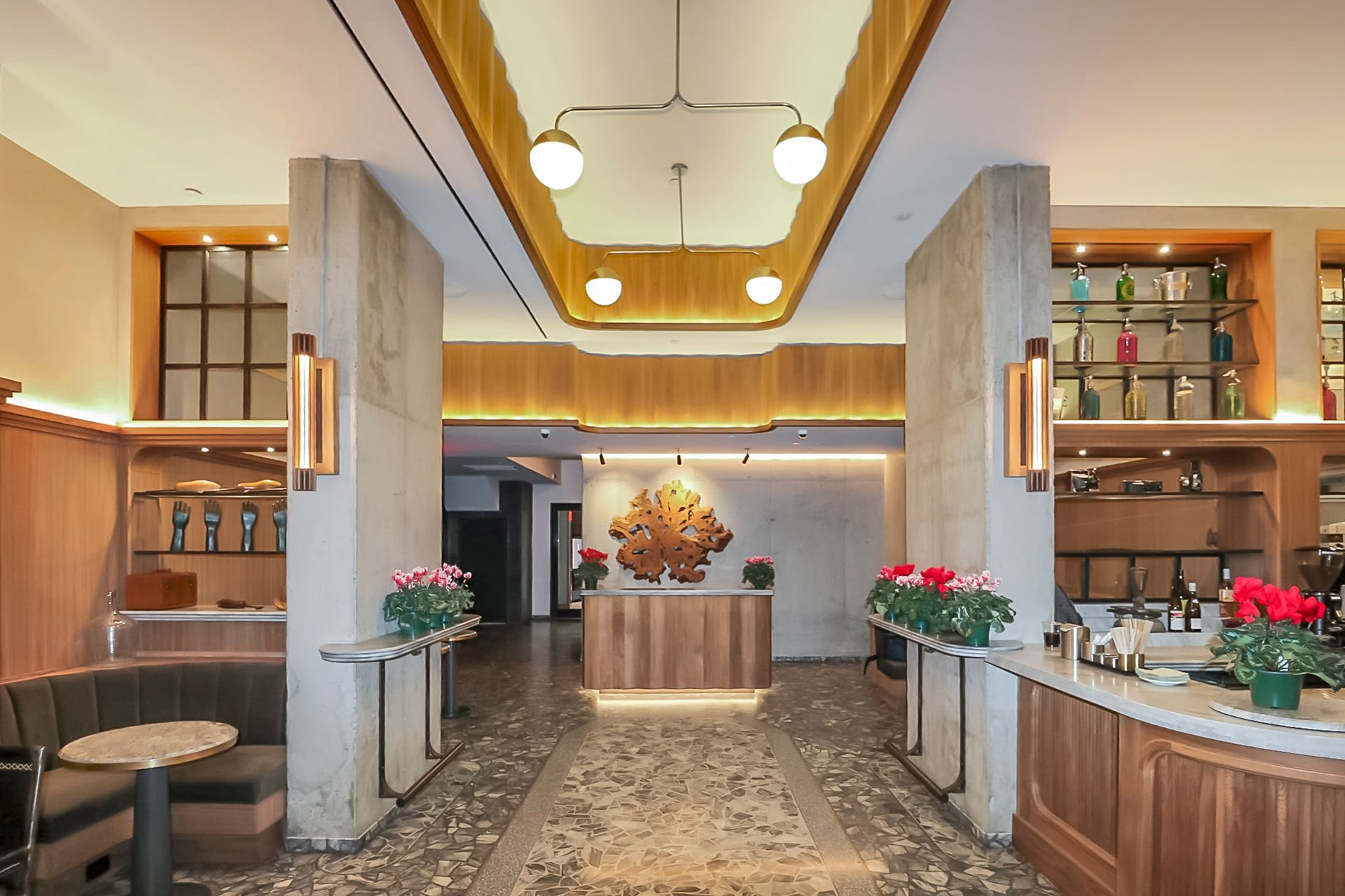 Hotel lobby with wooden paneling, marble floor, and floral arrangements.