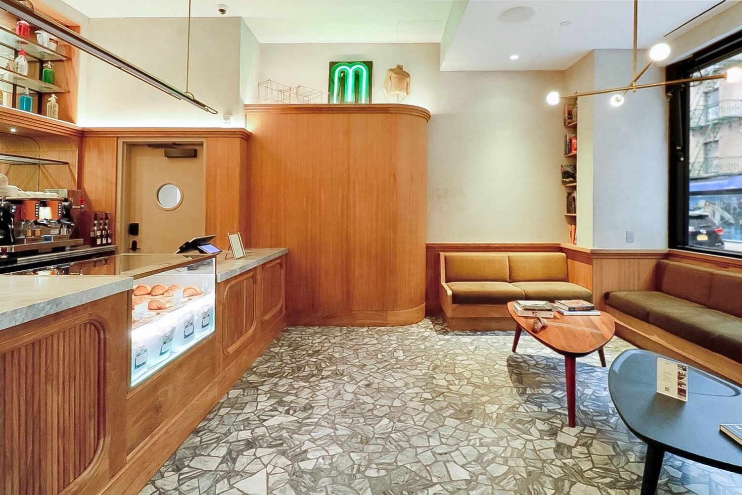 Interior of a cafe with a counter, seating, and a neon 