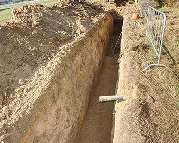 A large hole in the ground with a pipe in it.