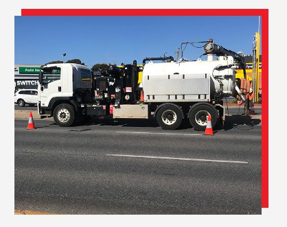 A vacuum truck is parked on the side of the road