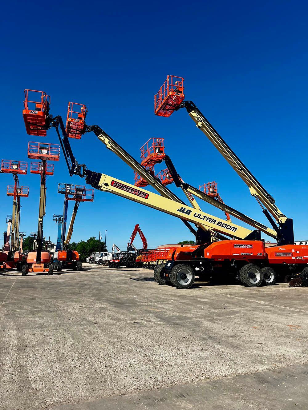 A bunch of jlg lifts are parked in a lot
