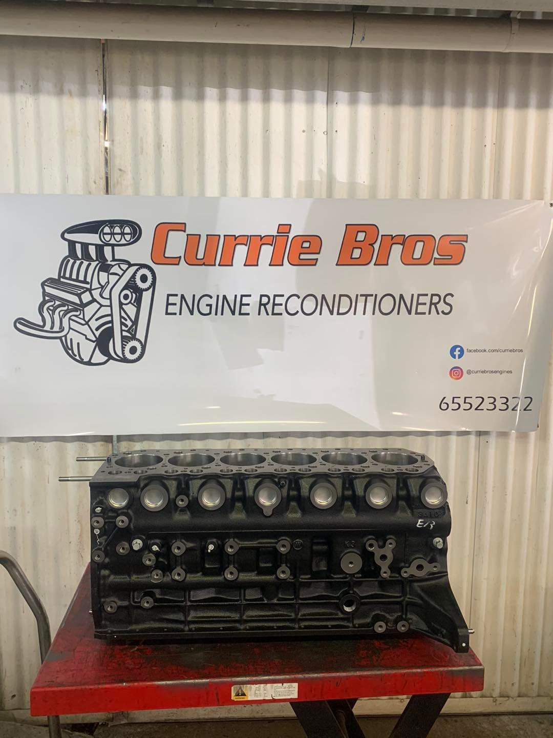 A Black Engine Block is Sitting on a Red Table — Currie Bros Engine Reconditioners in Kempsey, NSW
