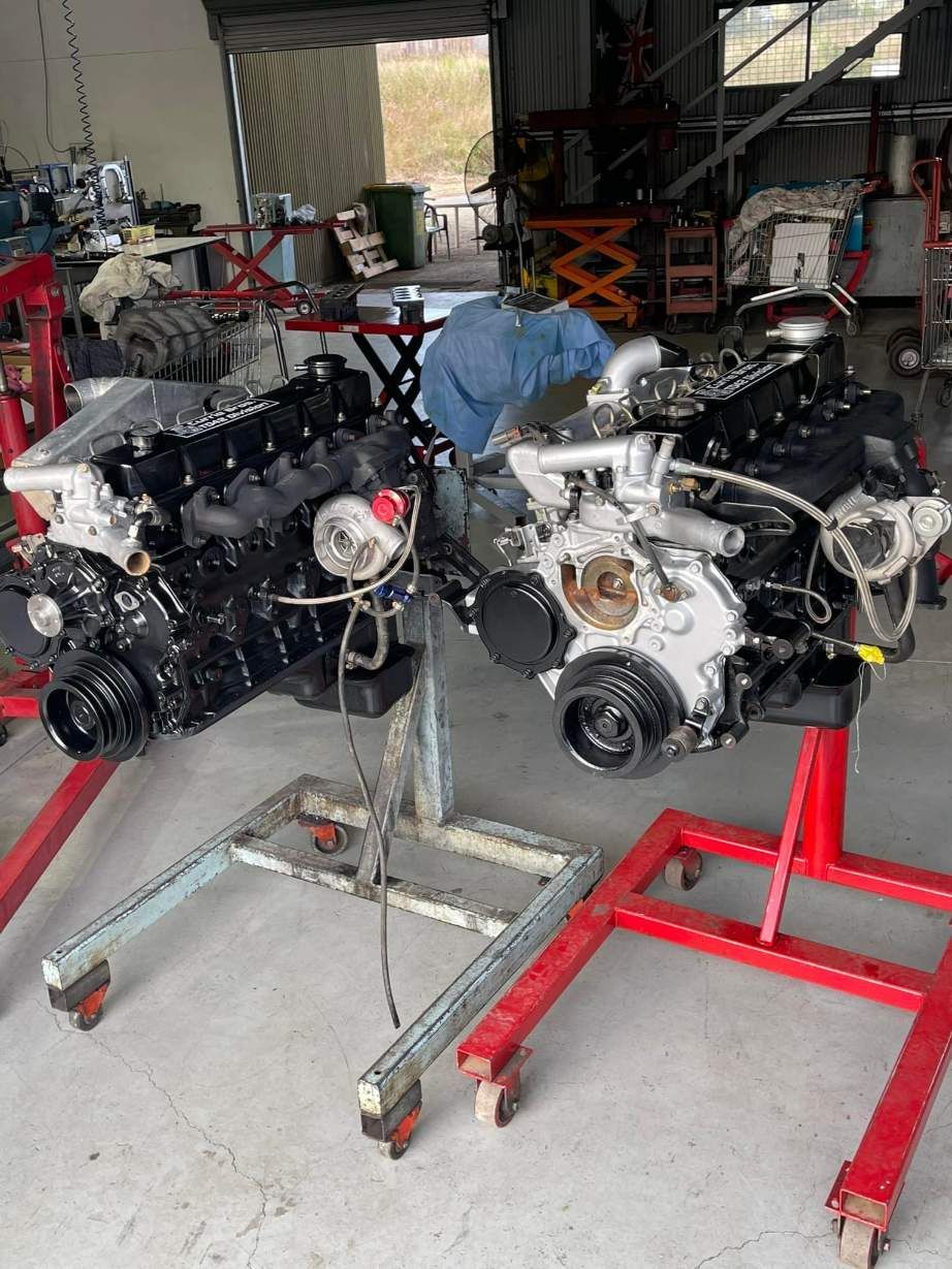 Two Engines Are Sitting on Red Stands in a Garage — Currie Bros Engine Reconditioners in Coffs Harbour, NSW