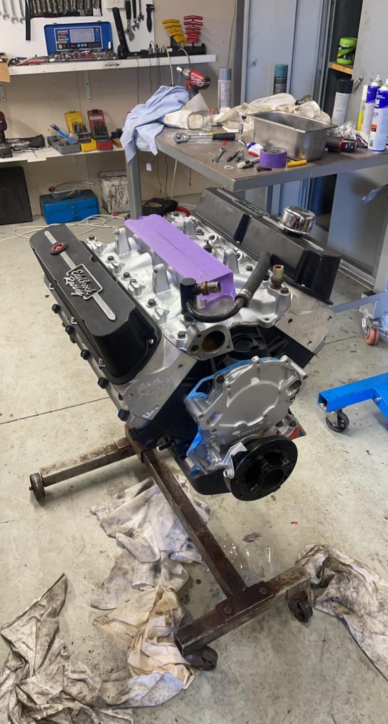 A Car Engine is Sitting on Top of a Table in a Garage — Currie Bros Engine Reconditioners in Laurieton, NSW