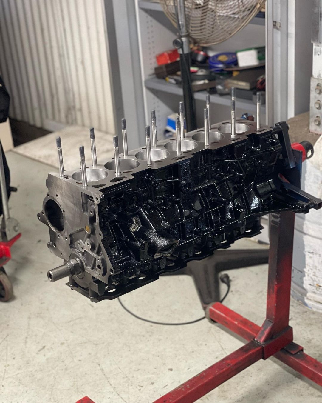 A Black Engine Block is Sitting on a Red Stand — Currie Bros Engine Reconditioners in Forster, NSW