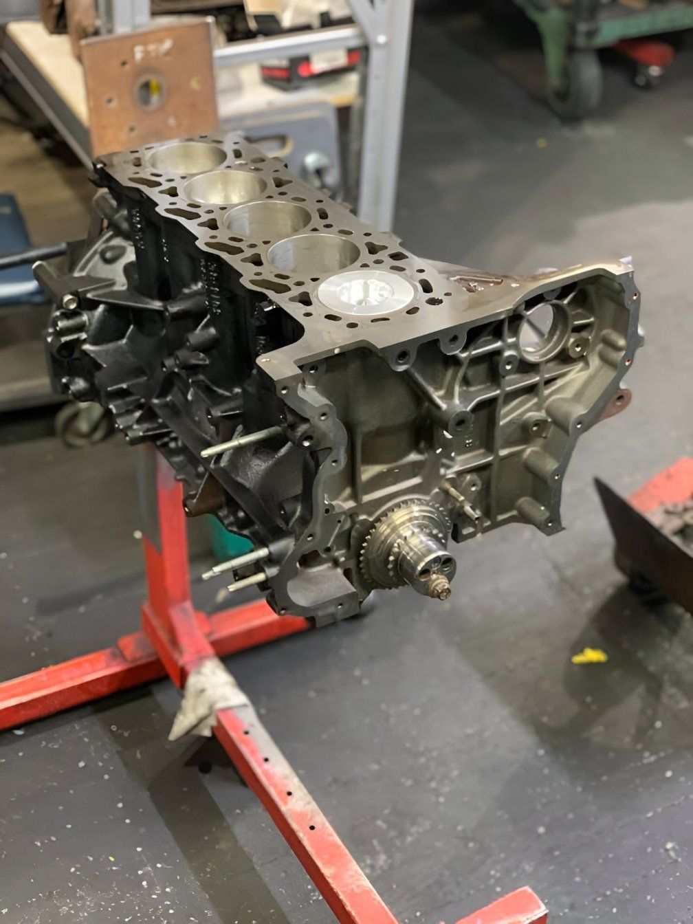 A Block of a Car Engine is Sitting on a Red Stand — Currie Bros Engine Reconditioners in Port Macquarie, NSW
