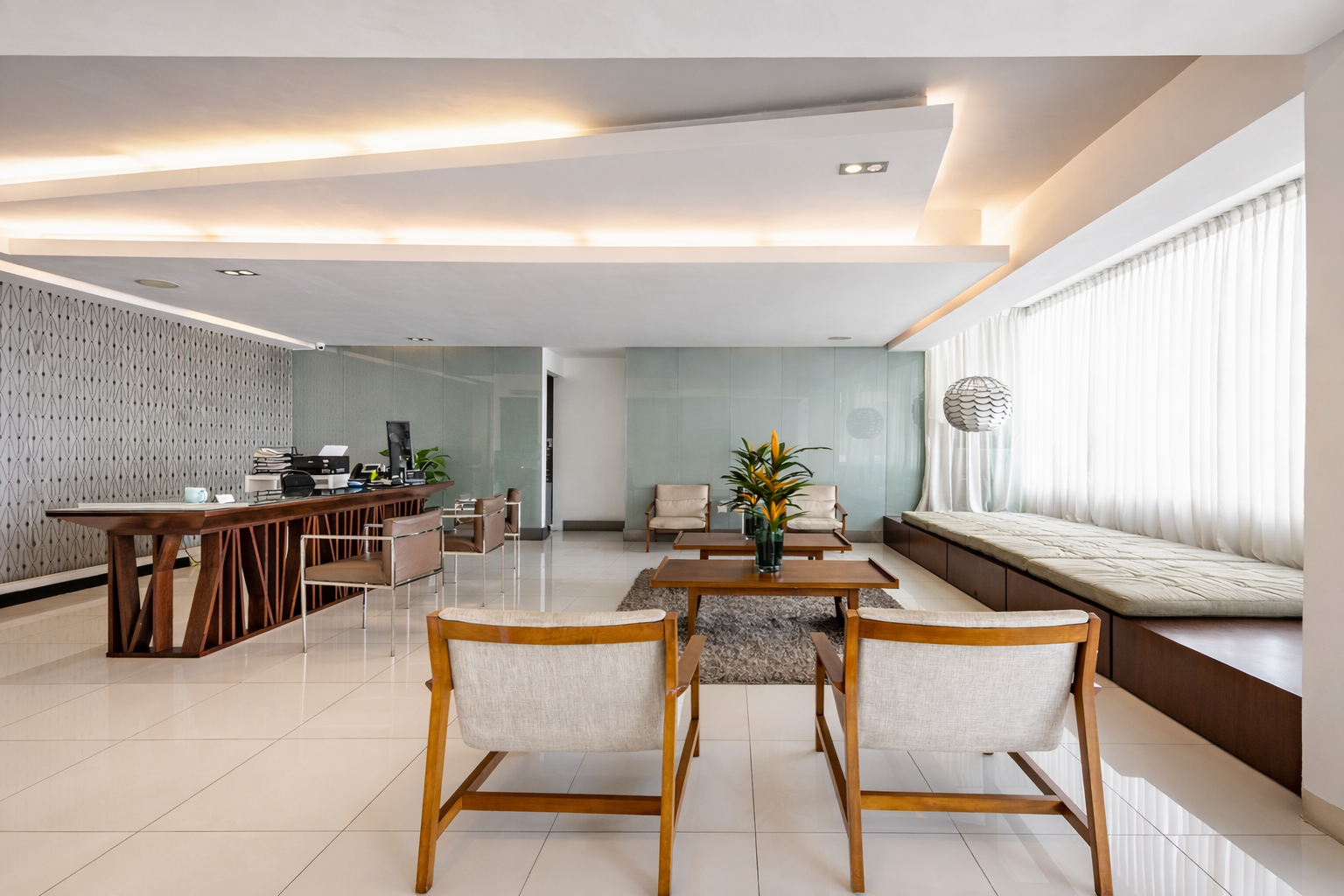 Salón-comedor moderno de planta abierta con suelos de baldosas blancas, muebles de madera y grandes ventanales con persianas.
