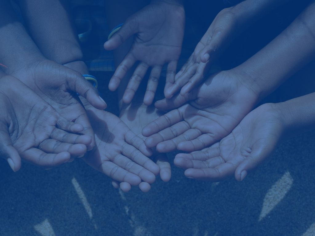 A group of people are holding their hands together in a circle.