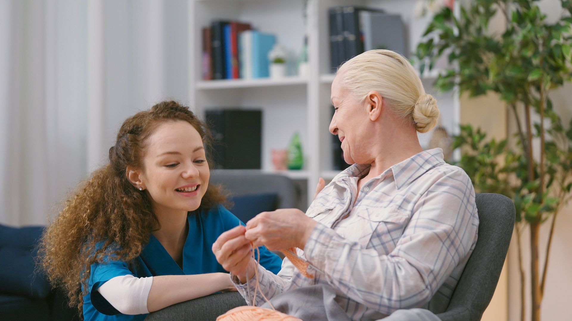 Caregiver gently helps a smiling patient with a nasal tube in a bright clinic room