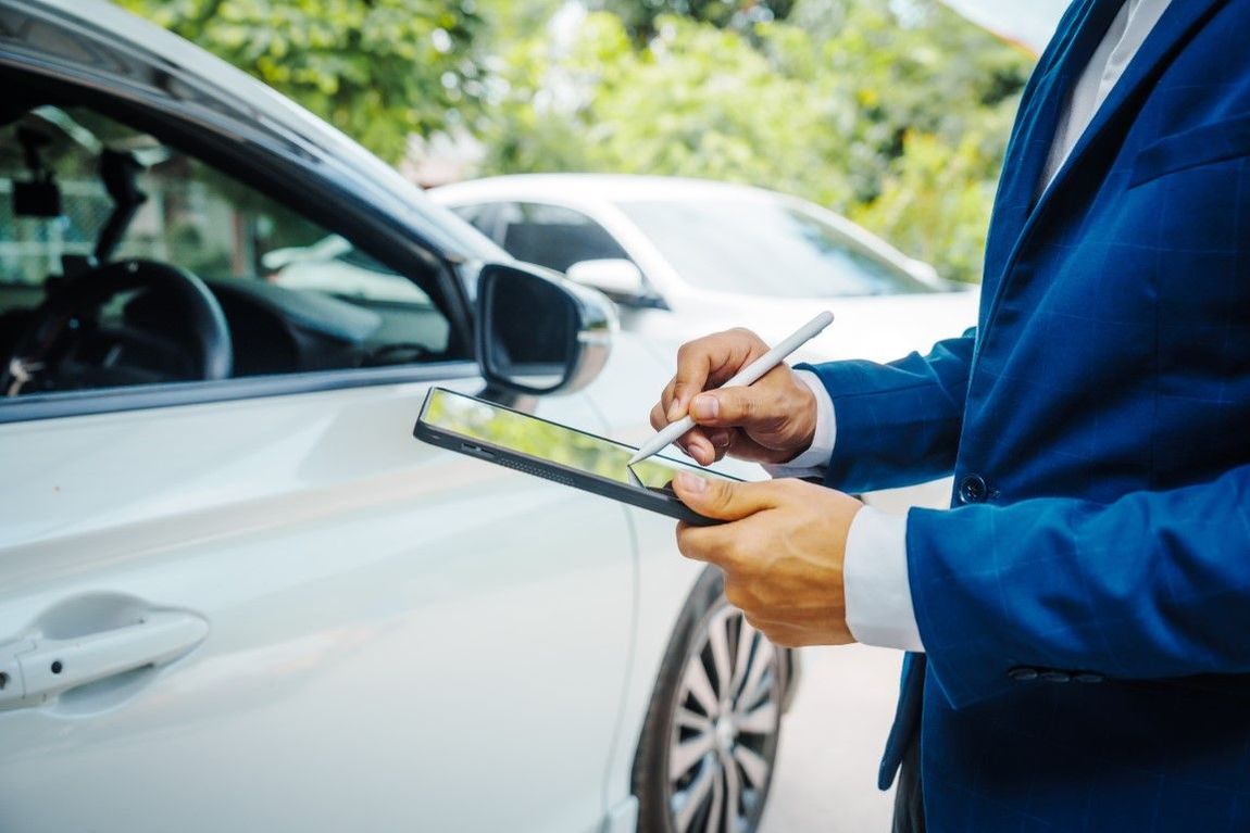 An image of a guy e-signing documents for damage to a vehicle.