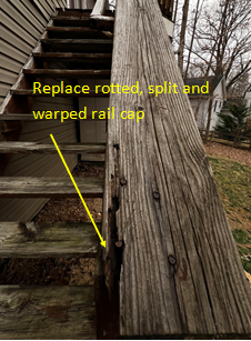 Rotted and split wood railing on outdoor stairs; repair needed.