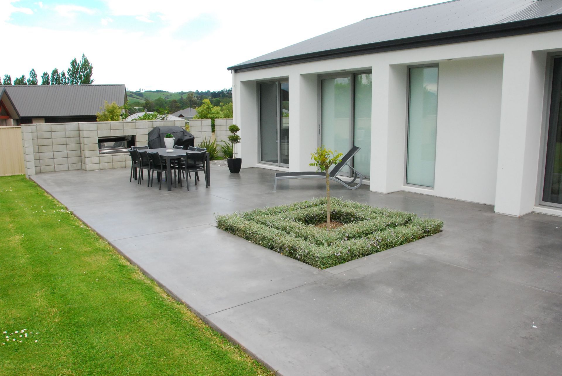 A patio with a table and chairs in front of a house.