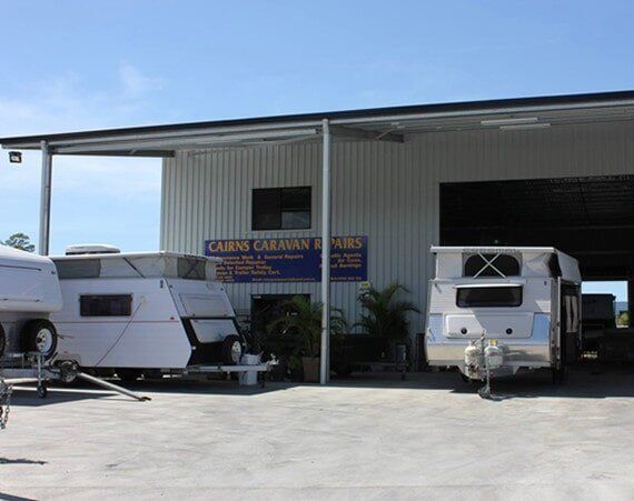Two Trailers Are Parked In Front Of A Building That Says Cabin Caravan Hire — Cairns Caravan Repairs In Edmonton, QLD