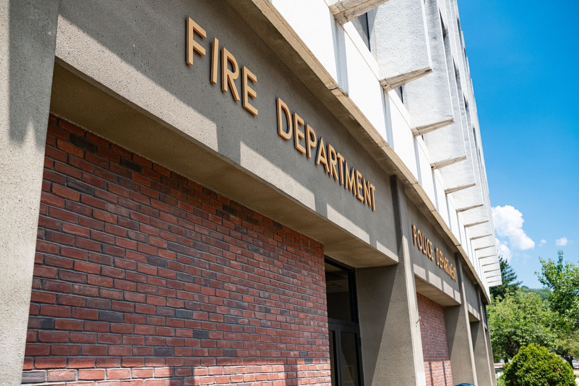 Fire Department brick building exterior with gold lettering against a blue sky.