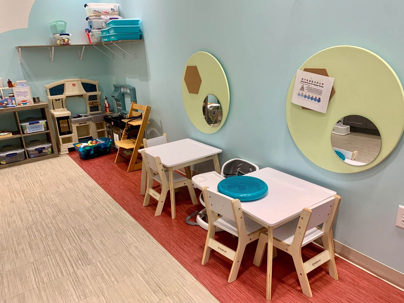 Playroom with small tables, toys, and light blue walls.